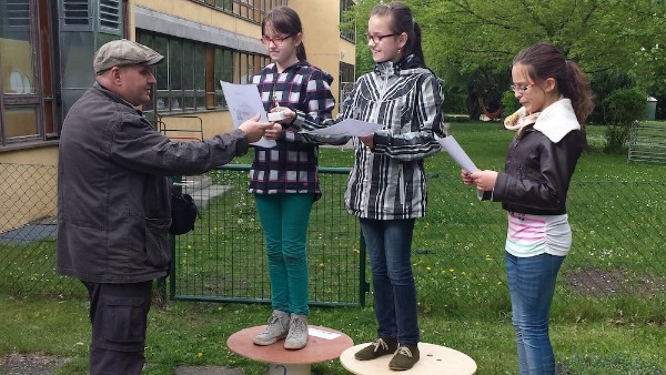 Die drei Gewinnerinnen des Kinderdartturniers (v.l. Fina, Sophie und Jasmin) nehmen ihre Preis von Sven Grelke, dem Trainer der Bogenschützen, entgegen.